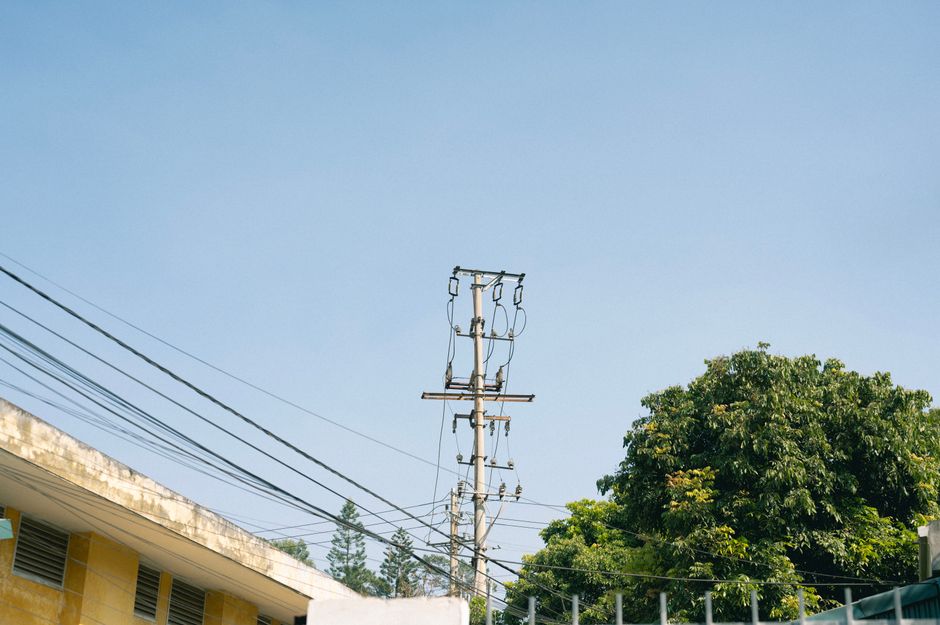 Power lines and a tree under a clear blue sky in Lang Son, Vietnam.