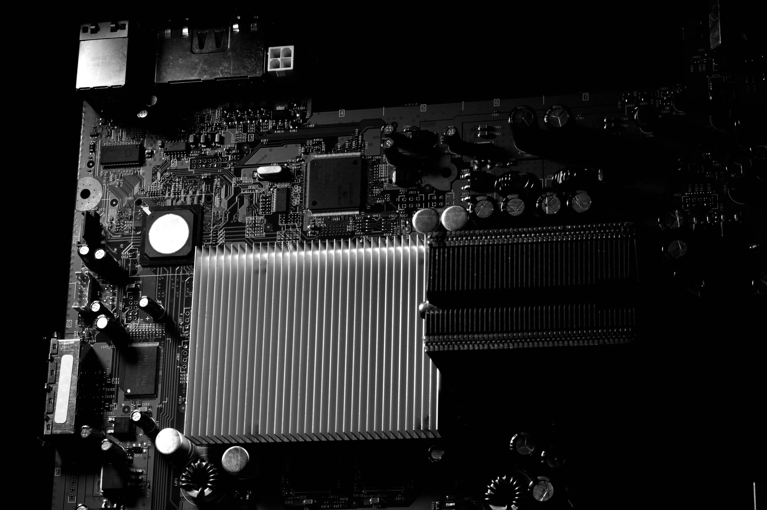 Detailed black and white photo of a computer motherboard highlighting the heatsink.