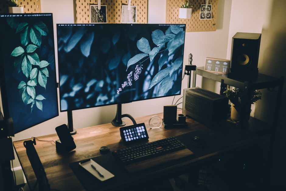 Stylish and functional home office with dual monitors, keyboard, and sound system, perfect for productivity and creativi