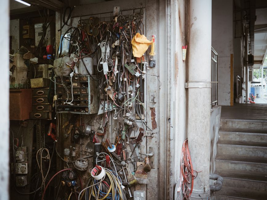 Wires, tools, and gadgets clutter the wall of a mechanic's workshop showcasing an industrial vibe.