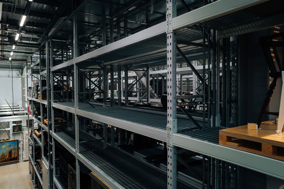 Empty metal storage racks in a spacious industrial warehouse setting.