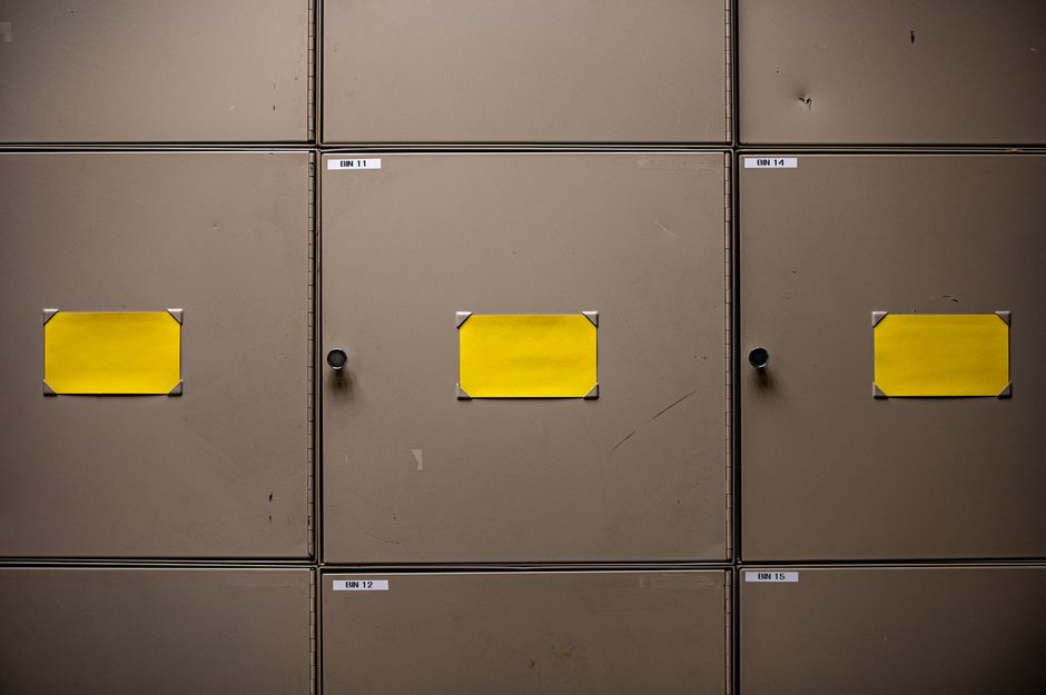 Steel cabinets with yellow labels for organization in an interior setting.