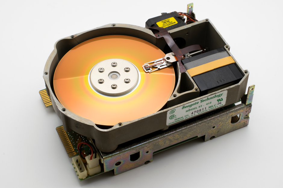 An open vintage Seagate ST-412 hard drive showcasing its internal components.