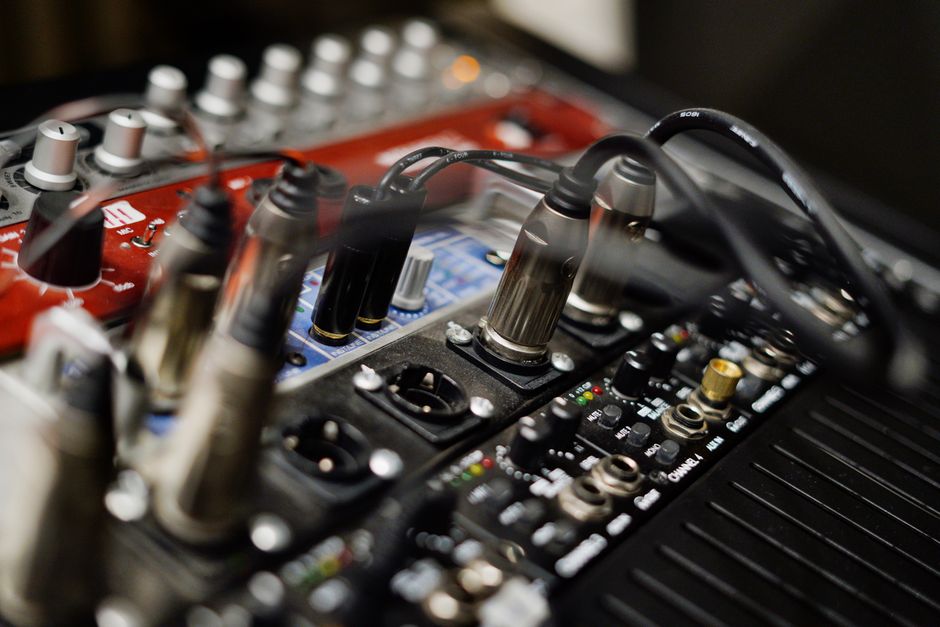 Detailed view of audio equipment with cables and sound card connections in a studio setting.