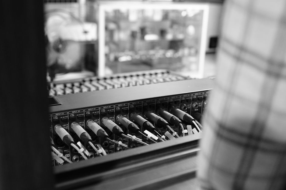 Close-up view of audio equipment with patch cables in black and white, highlighting technology and connection.