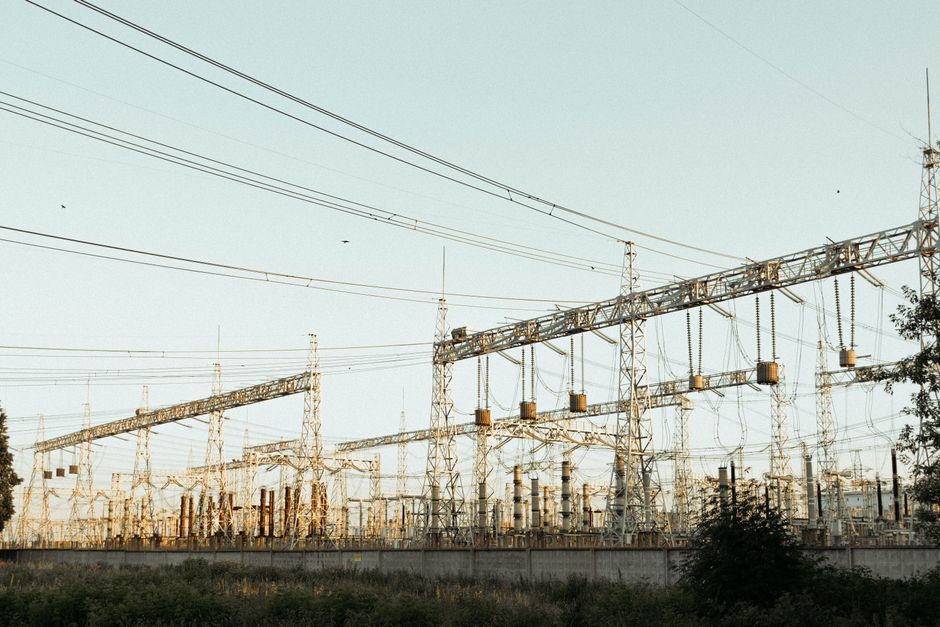 A wide view of an industrial electrical substation with power lines and towers outdoors.