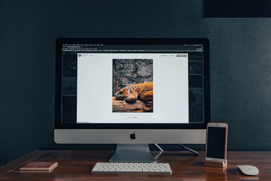 Stylish indoor workspace with a computer and smartphone on a wooden desk.